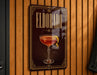 A decorative sign for "Eldorado" cocktail, featuring an illustration of a cocktail glass with a lemon peel.