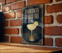 A framed poster of a cocktail called "Florida Daiquiri" is displayed on a brick wall.