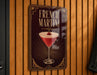 A sign for a French martini is hanging on a wooden wall.