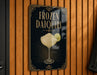A sign for "FROZEN DAIQUIRI" is displayed on a wooden wall, featuring an illustration of a cocktail glass with a lime slice.