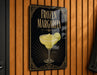 A sign for a frozen margarita is hanging on a wooden wall.