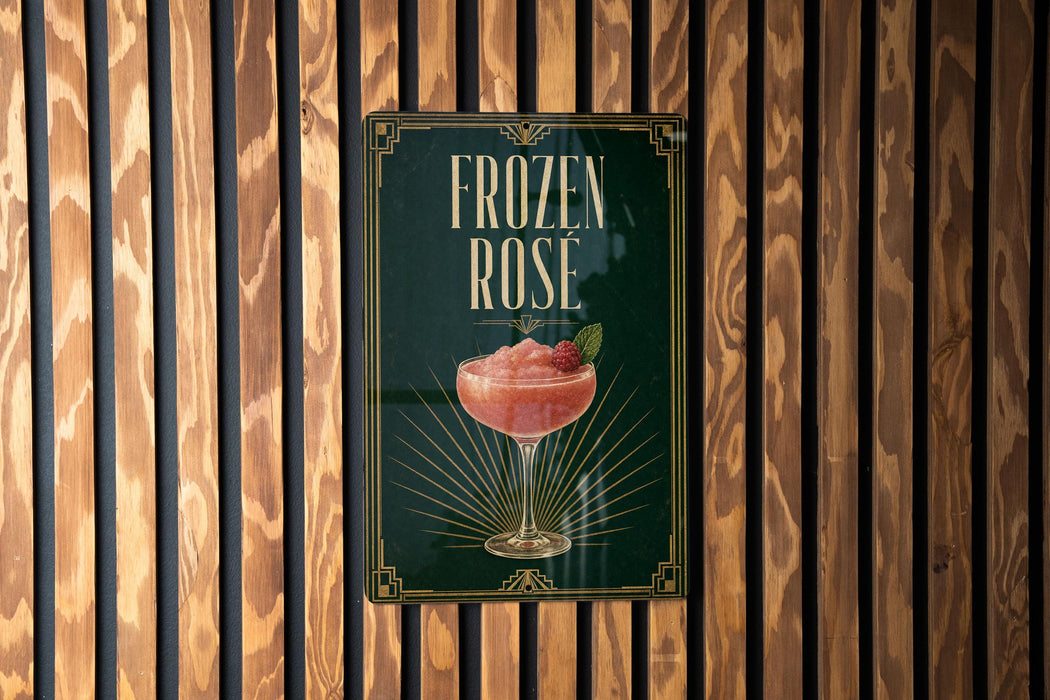 A sign for a frozen rose cocktail is displayed on a wooden wall.