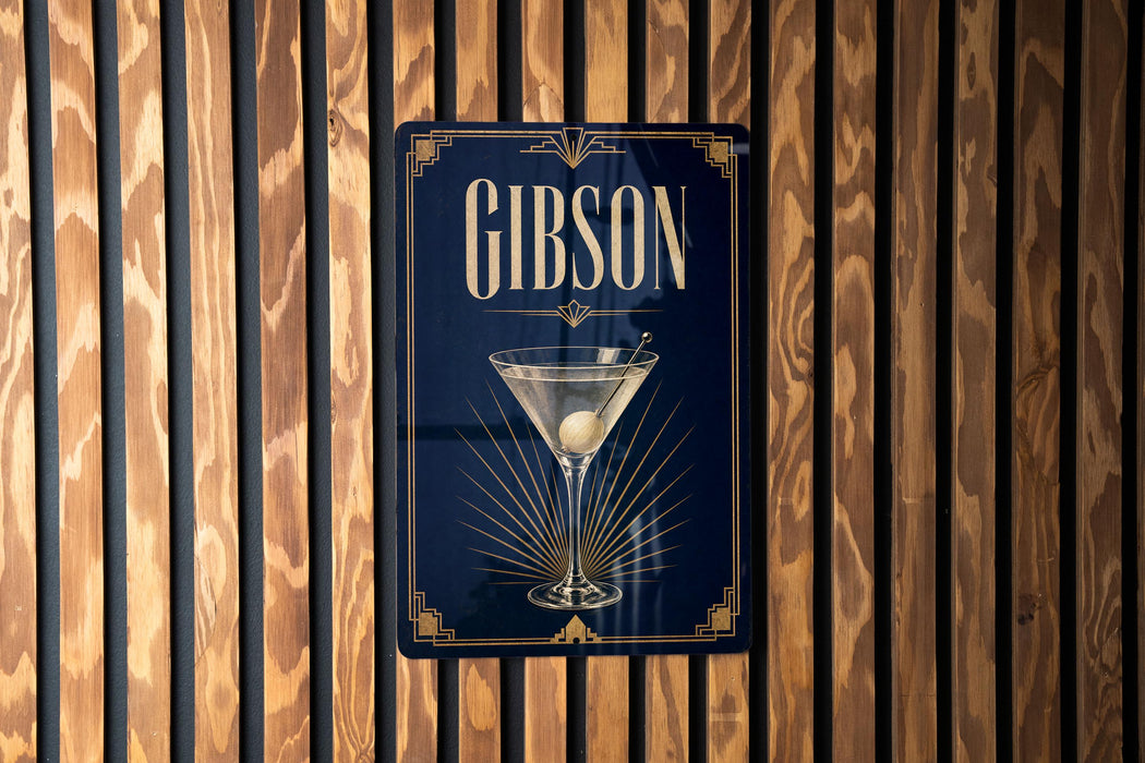 A sign for a bar called "Gibson" with a martini glass illustration on a dark blue background.