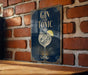 A sign with the text "GIN AND TONIC" and an illustration of a gin and tonic glass, hanging on a brick wall.