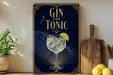A framed poster with the text "GIN AND TONIC" and an illustration of a gin and tonic glass with a lime slice.