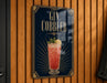 A sign for a gin cobler cocktail is displayed on a wooden wall.