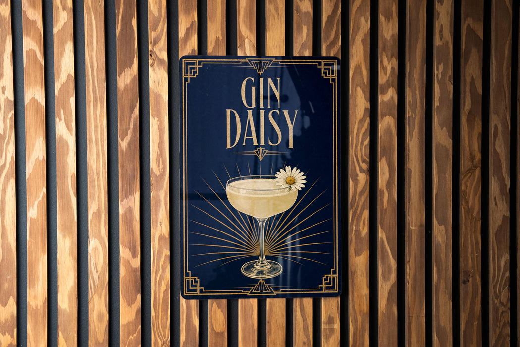 A decorative sign with the text "GIN DAISY" and an illustration of a cocktail glass with a flower on it, mounted on a wooden wall.
