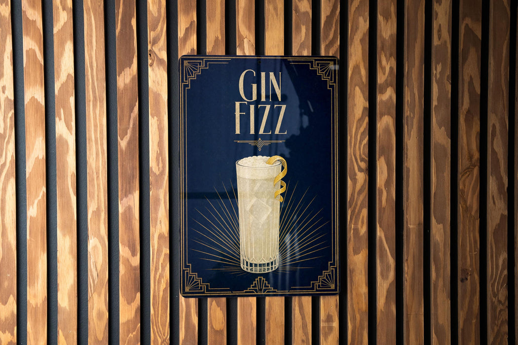 A sign with the text "GIN Fizz" and an illustration of a cocktail glass is displayed against a wooden wall.