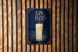 A sign with the text "GIN Fizz" and an illustration of a cocktail glass is displayed against a wooden wall.