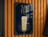 A sign for a gin fizz cocktail is displayed on a wooden wall.