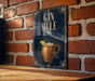 A sign with the text "GIN MULE" and an illustration of a copper mug with a lemon slice, mounted on a brick wall.