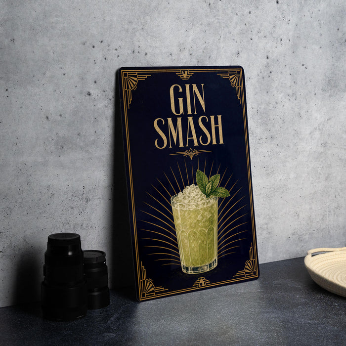 A decorative sign with the text "GIN SMASH" and an illustration of a cocktail, placed on a gray countertop next to a stack of black containers.