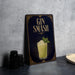 A decorative sign with the text "GIN SMASH" and an illustration of a cocktail, placed on a gray countertop next to a stack of black containers.