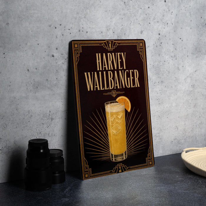 A framed poster of a cocktail called "Harvey Wallbanger" is displayed on a gray wall, accompanied by a stack of black camera lenses and a white dish.