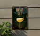 A sign for a honey bee cocktail is displayed on a wall, with a plant visible to the left.