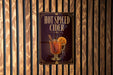 A sign for "Hot Spiced Cider" is displayed on a wooden wall.