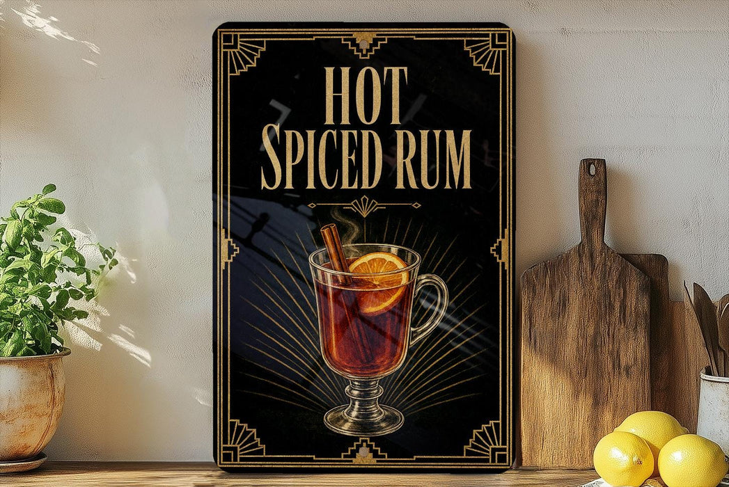 A framed advertisement for "Hot Spiced Rum" featuring an illustration of a glass of hot rum with a slice of lemon and a cinnamon stick.