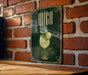 A poster with a green background and gold accents, featuring an illustration of a drink with a lime slice and a decorative border.