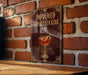 a sign with the title "IMPROVED WHISKEY COCKTAIL" and an illustration of a cocktail glass with a lemon slice.