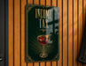 A sign on a wooden wall that reads "INCOME TAX" with an illustration of a martini glass containing a cherry on top.