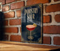 A poster with the title "INDUSTRY SOUR" and an illustration of a cocktail on a wooden surface against a brick wall background.