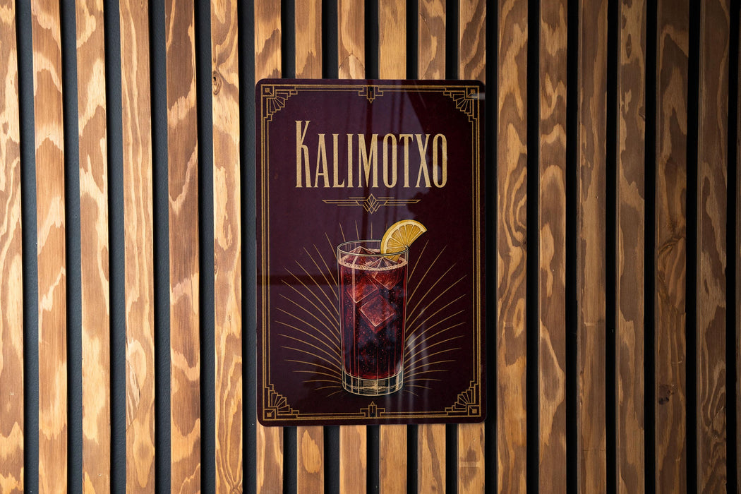 A sign for a drink called "Kalimotxo" is displayed on a wooden wall.