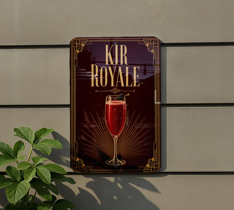 a sign for "Kir Royale" cocktail, which is a red drink with a garnish, displayed on a wall.