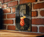 A framed poster with the text "Lava Flow" and an illustration of a colorful drink is displayed on a brick wall.