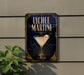 A sign for Lychee Martini, featuring a martini glass with a slice of lychee fruit on the rim, is displayed on a wall.