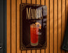 A decorative sign for Madras cocktails hangs on a wooden wall.