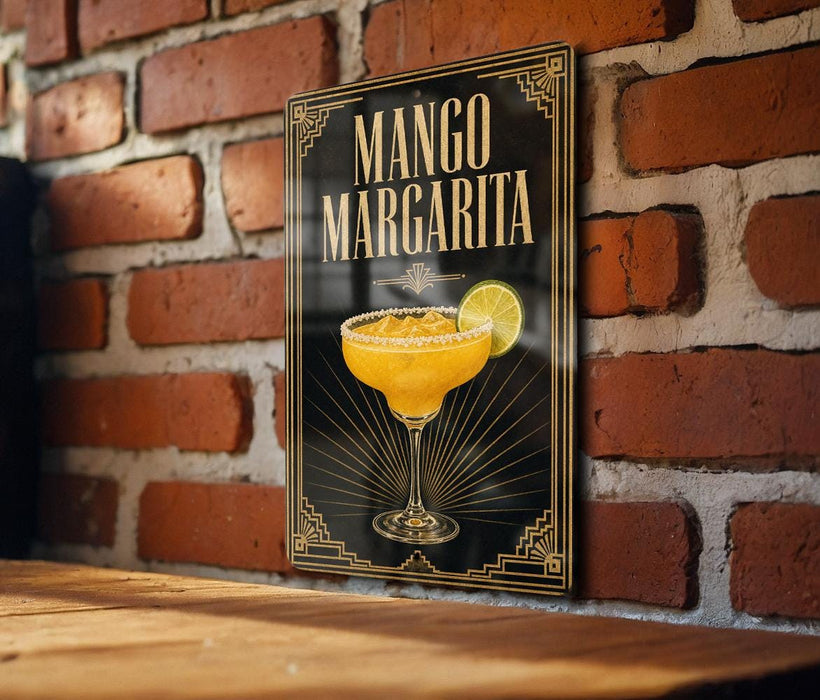 A framed poster of a mango margarita cocktail is displayed on a brick wall.