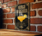 A framed poster of a mango margarita cocktail is displayed on a brick wall.