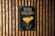 A poster for a mango margarita cocktail is displayed on a wooden wall.