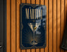 A sign with the word "MARTINI" prominently displayed, featuring an illustration of a martini glass with a green olive.