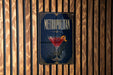 A poster for "Metropolitan" cocktail, featuring a martini glass with a cocktail in it, is displayed on a wooden wall.