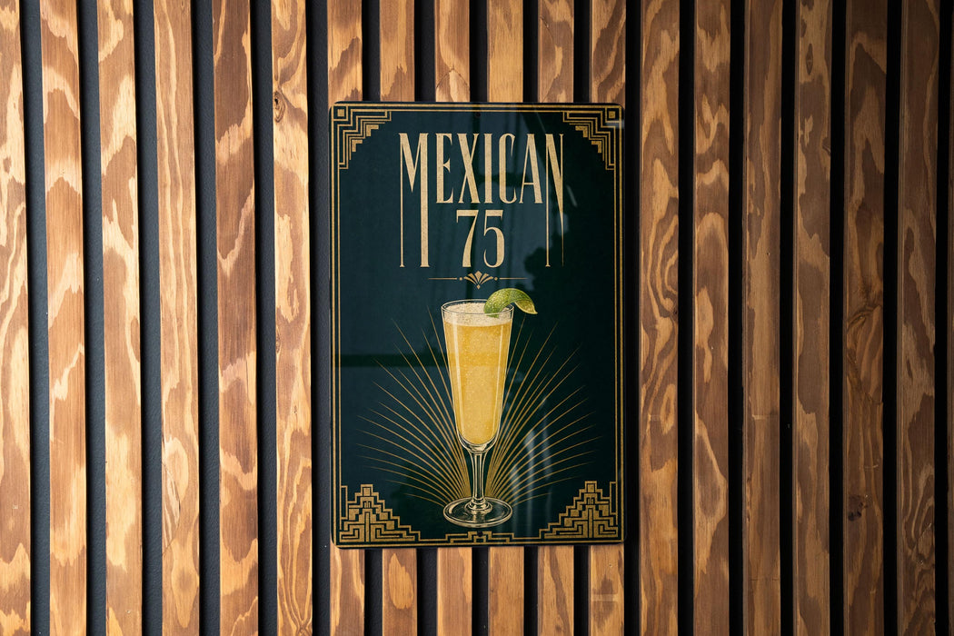 A poster with the text "MEXICAN 75" and an illustration of a drink, displayed on a wooden wall.