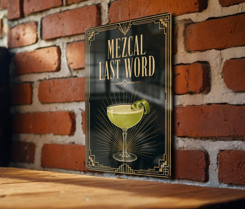 A framed poster with the text "MEZCAL LAST WORD" and an illustration of a cocktail glass on a brick wall.