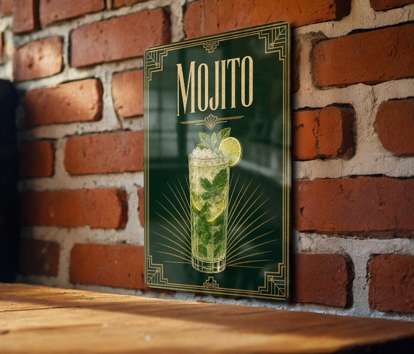 A framed poster of a mojito cocktail is displayed on a brick wall, with a wooden table below it.
