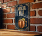 A poster or sign for a Moscow Mule cocktail, featuring an illustration of a copper mug with a lemon slice.