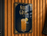 A sign for a drink called "NAVY GROG" is displayed on a wooden wall.