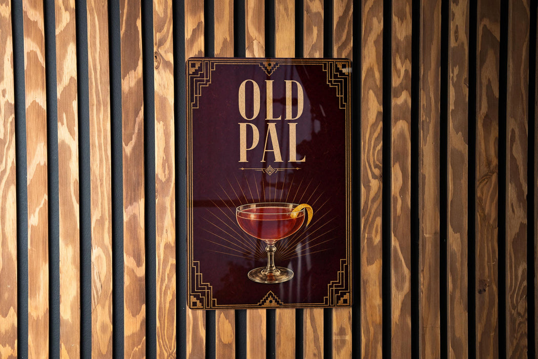 a sign with the text "OLD PAL" and an illustration of a glass containing a red liquid, likely a cocktail or wine.