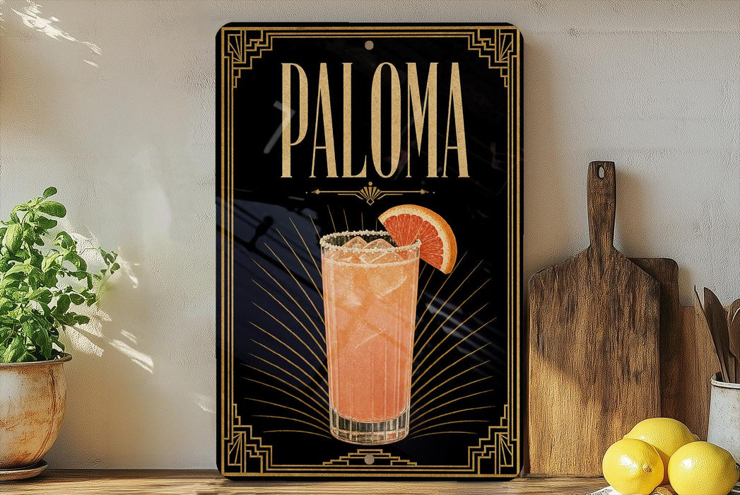 A framed advertisement for a cocktail called "Paloma" featuring a glass of the drink with a slice of orange on the rim.