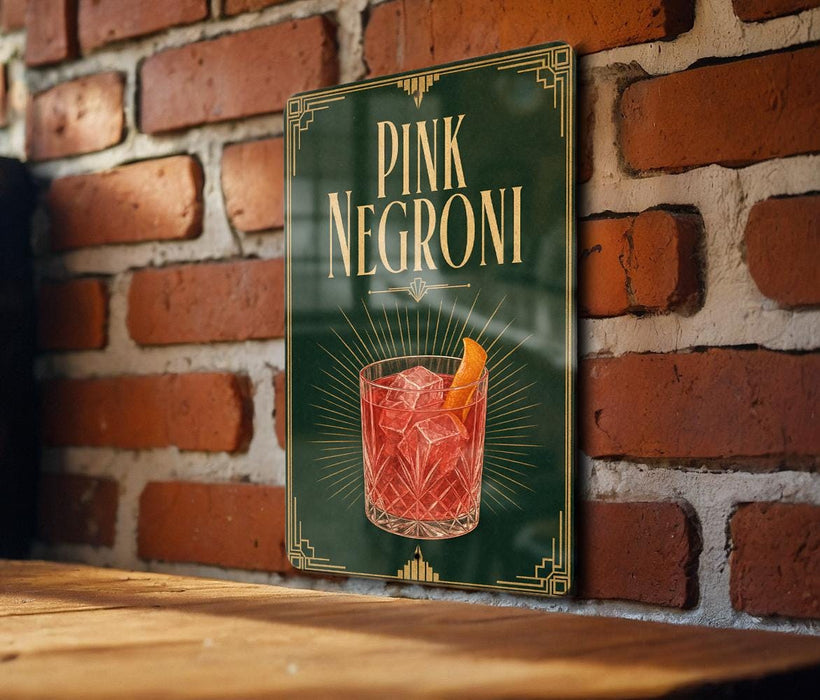 A sign for "PINK NEGRONI" is displayed on a brick wall, featuring an illustration of a pink cocktail with an orange slice.