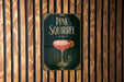 A poster advertising a pink squirrel cocktail is displayed on a wooden wall.