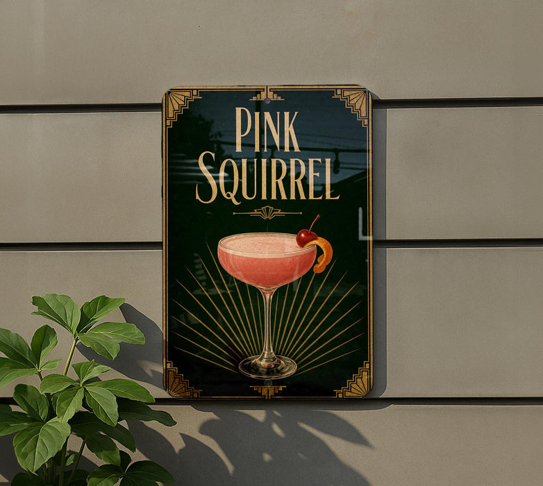 A sign for a pink squirrel cocktail is displayed on a wall, with a plant visible to the left.