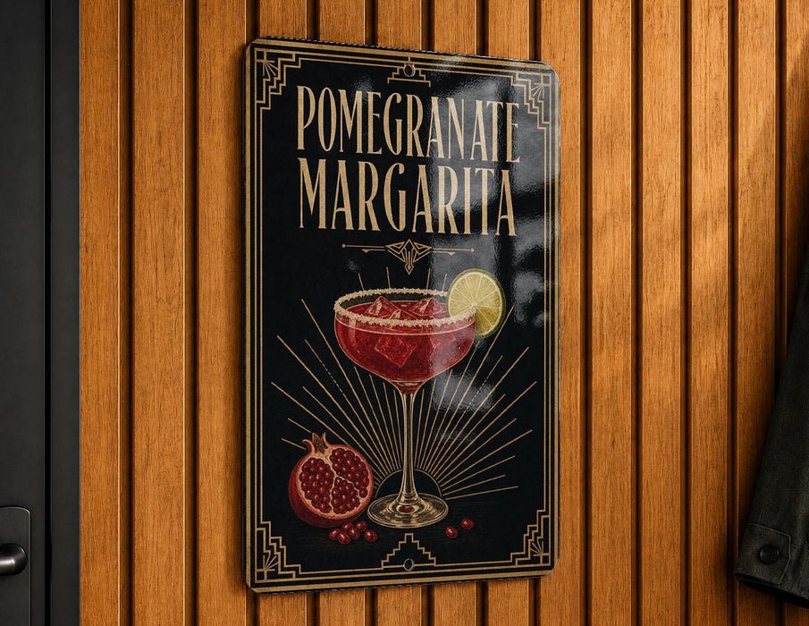 A decorative sign for a pomegranate margarita cocktail, featuring a glass of the drink and garnished with pomegranate slices and a lemon wedge.