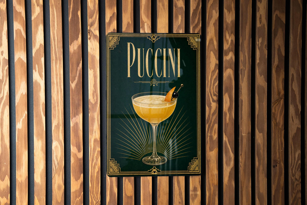 A poster with the word "PUCCINI" displayed prominently, featuring an illustration of a cocktail glass with a garnish.