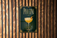 A poster with the word "PUCCINI" displayed prominently, featuring an illustration of a cocktail glass with a garnish.