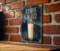 A poster advertising "RAMOS GIN FIZZ" is displayed on a brick wall, featuring a glass of the cocktail with a garnish on top.