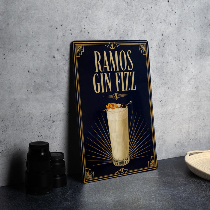 A framed poster advertising a drink called "RAMOS GIN FIZZ" on a dark background with a decorative border.